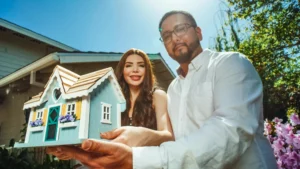 Young couple shaking hands with real estate agent during a property negotiation in a modern home setting.